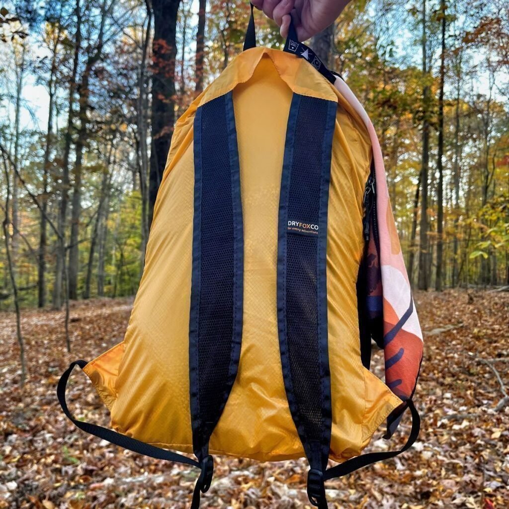 orange compact backpack from back showing straps