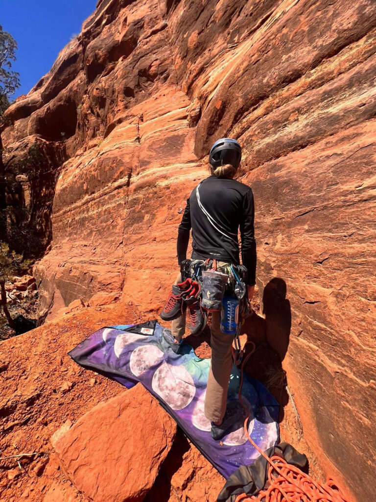 man with travel towel rock climbing