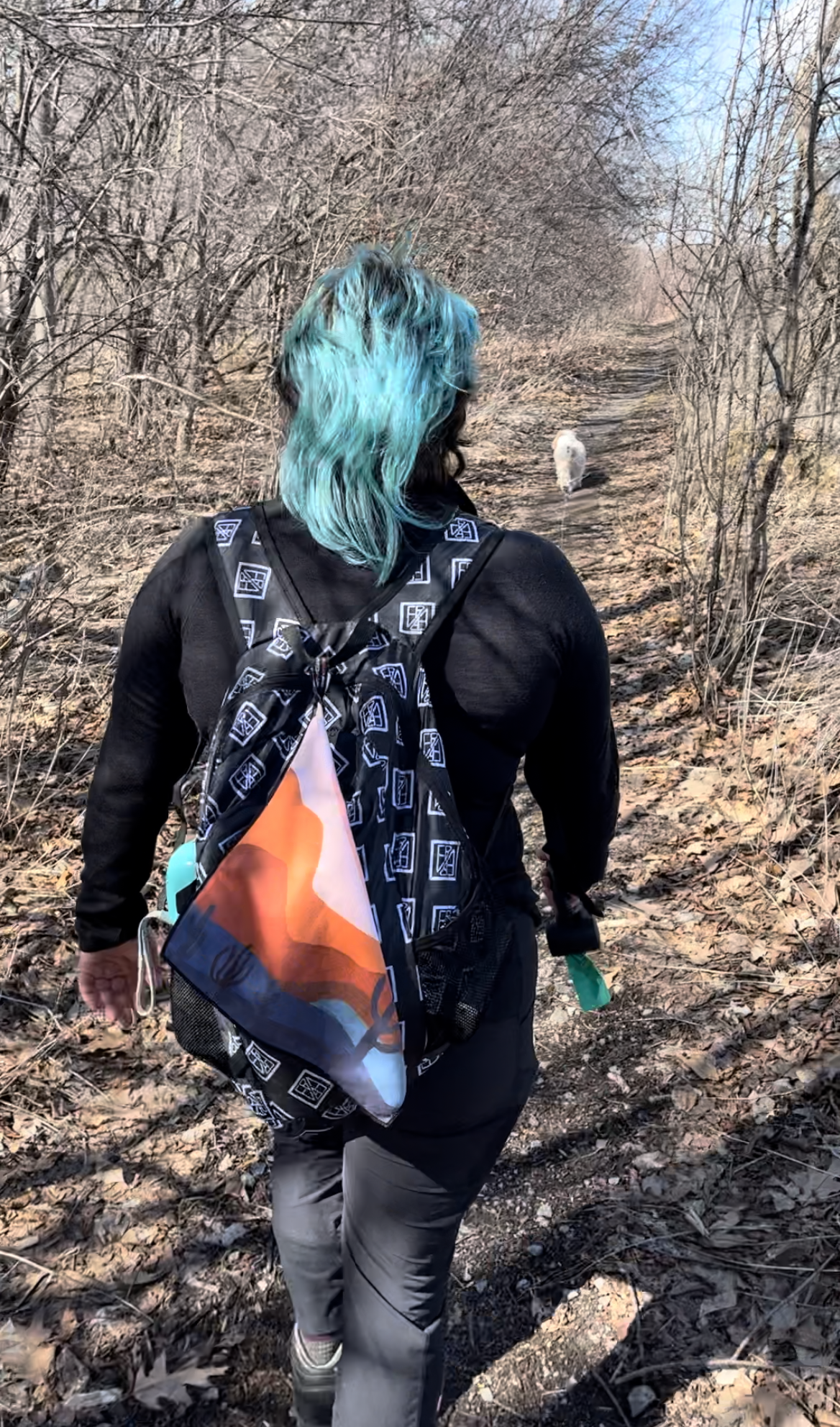 women with travel towel on backpack walking dog in forest